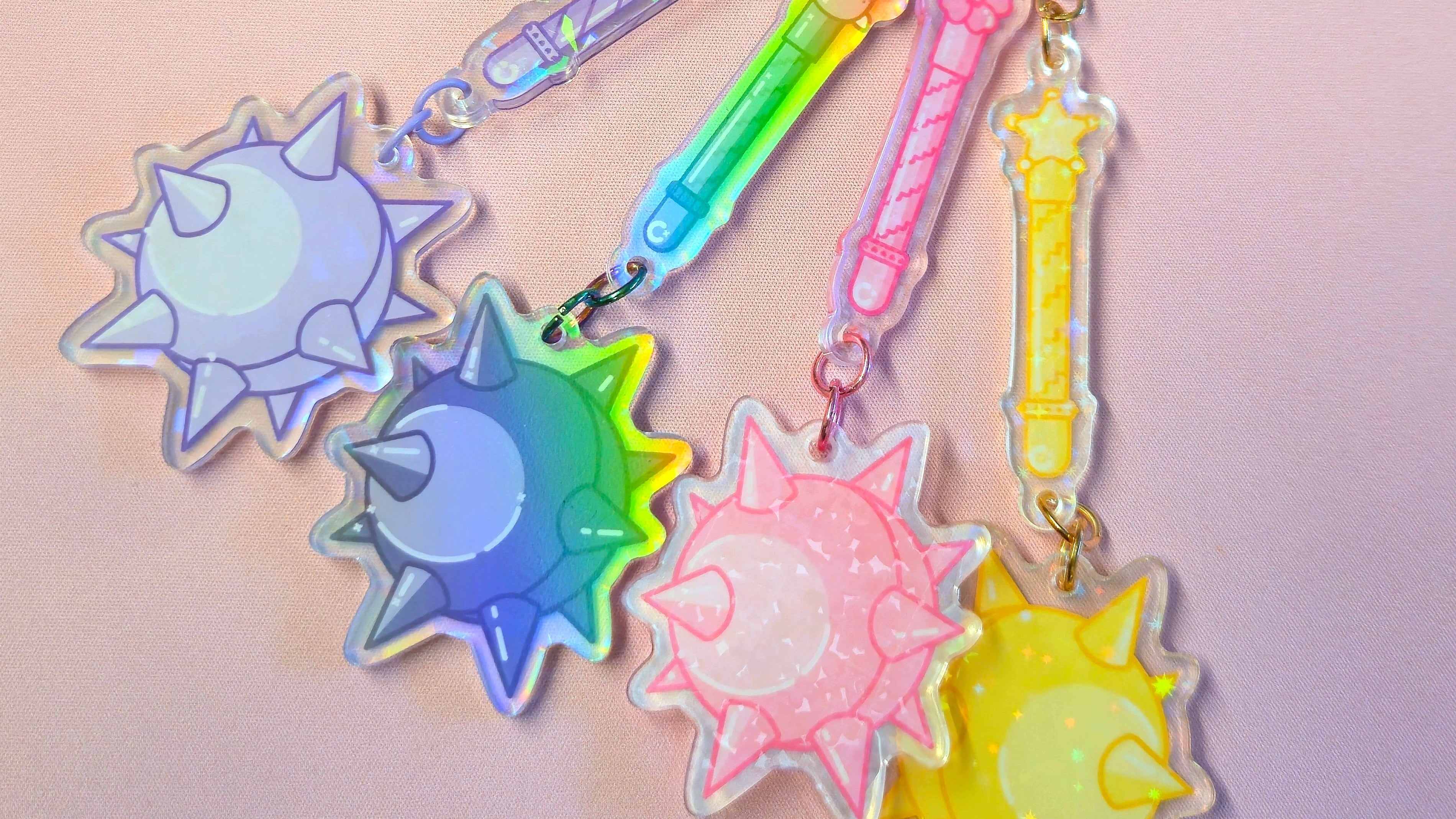 Colorful keychain with sun-shaped charms on a light pink background