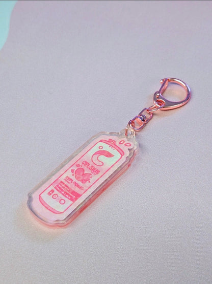 Pink keychain with a cartoon design on a light gray background